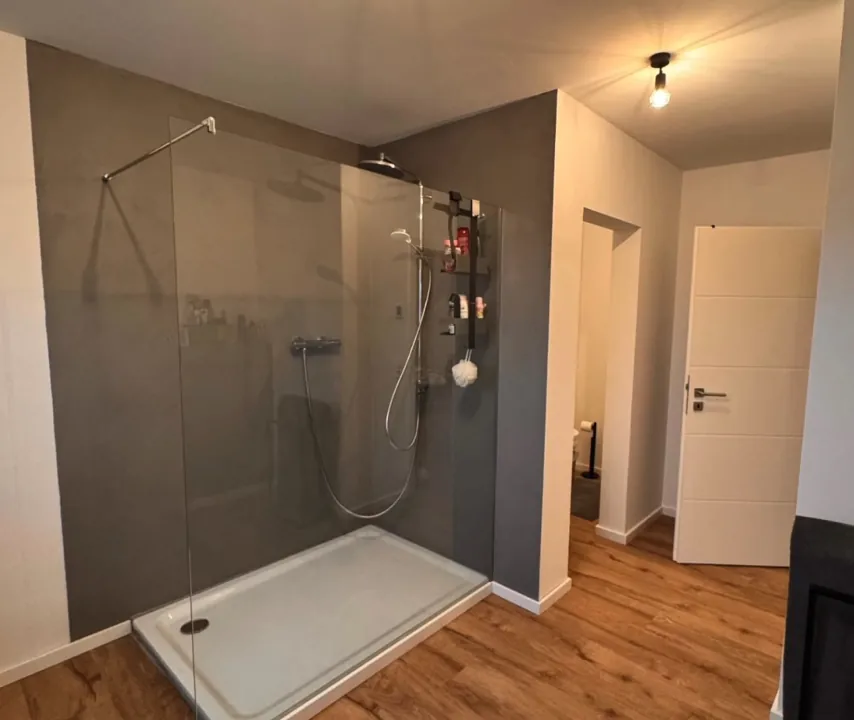 Fugenloses Bad und begehbare Dusche - Gestaltung eines modernen Badezimmers mit fugenlosen Wänden im Duschbereich und passenden Bodenbelägen.