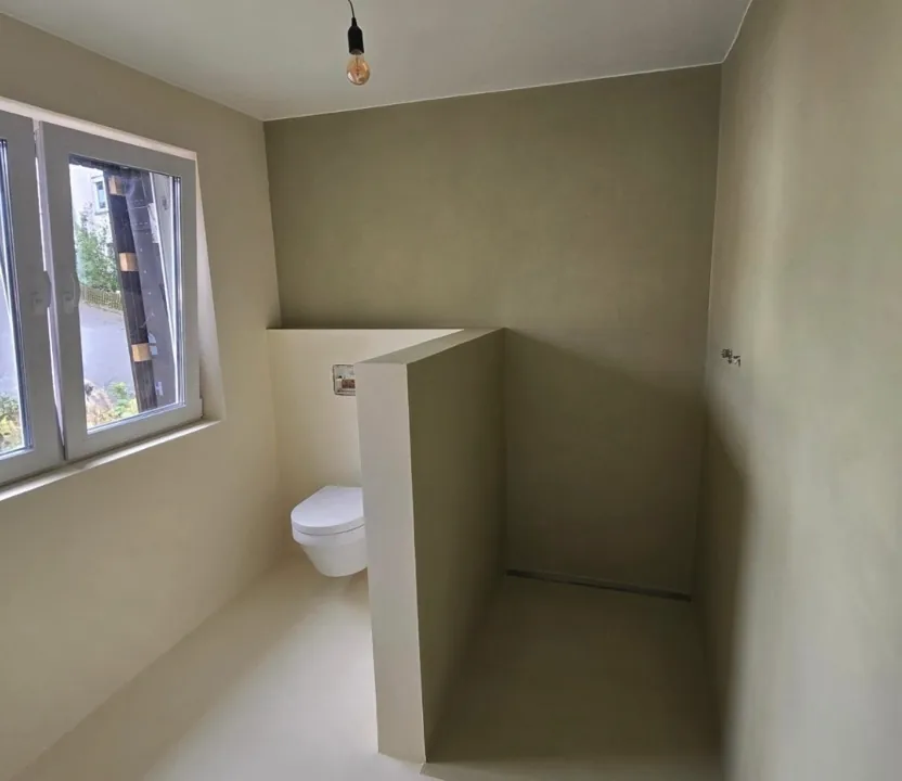 Badezimmer Microzement fugenlos - Fugenloses Badezimmer mit Spachteltechnik Wänden und passendem Boden in Grüntönen. Modernes und pflegeleichtes Oberflächenfinish.